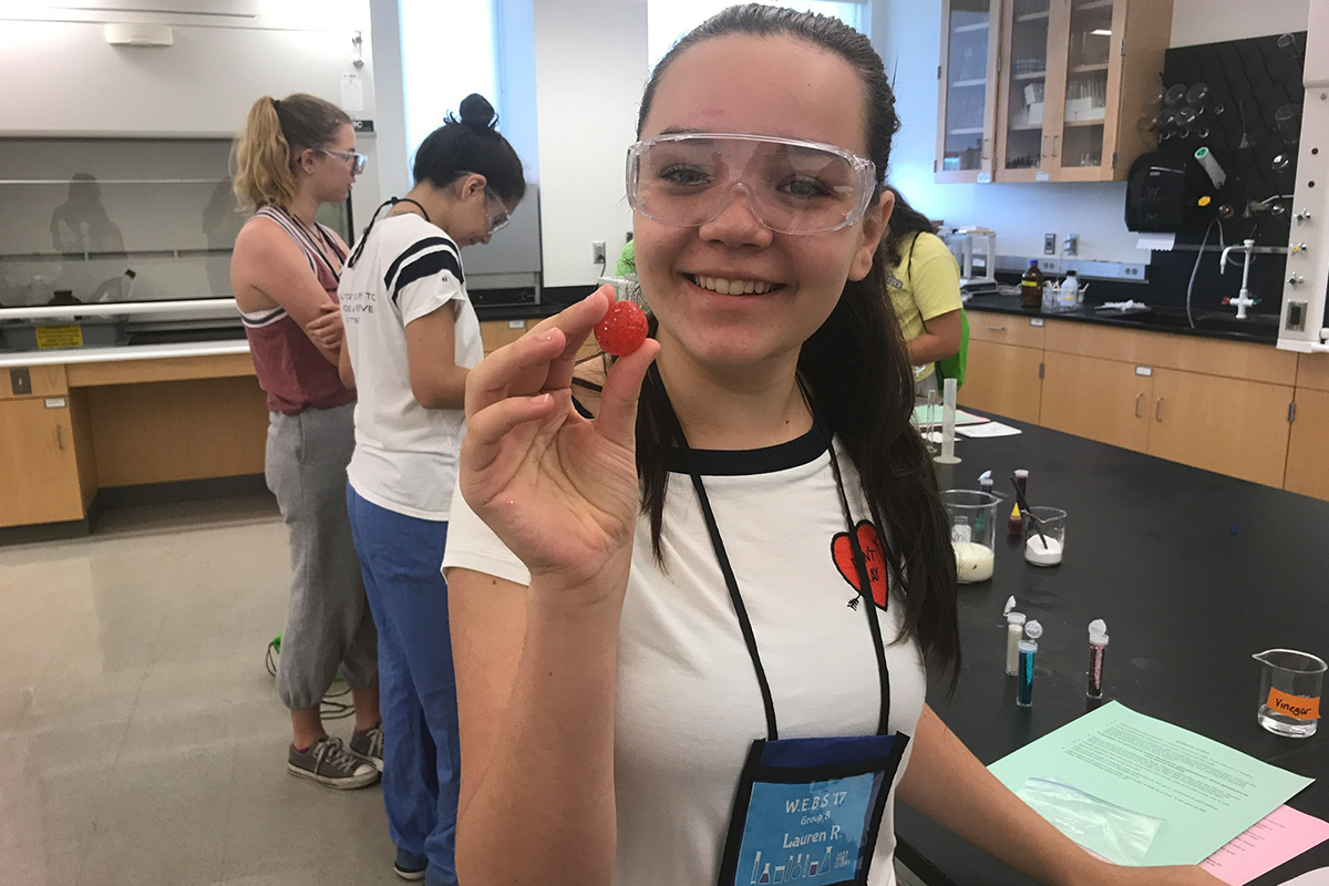 Student holds a raspberry as part of a hands-on lab.